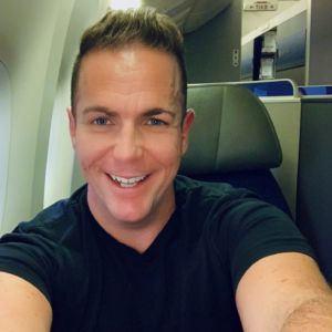 Happy smiley on the plane travel selfie of Ross Johnson